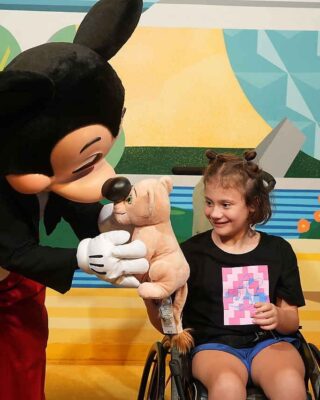 Emory showing Mickey Mouse her Simba toy